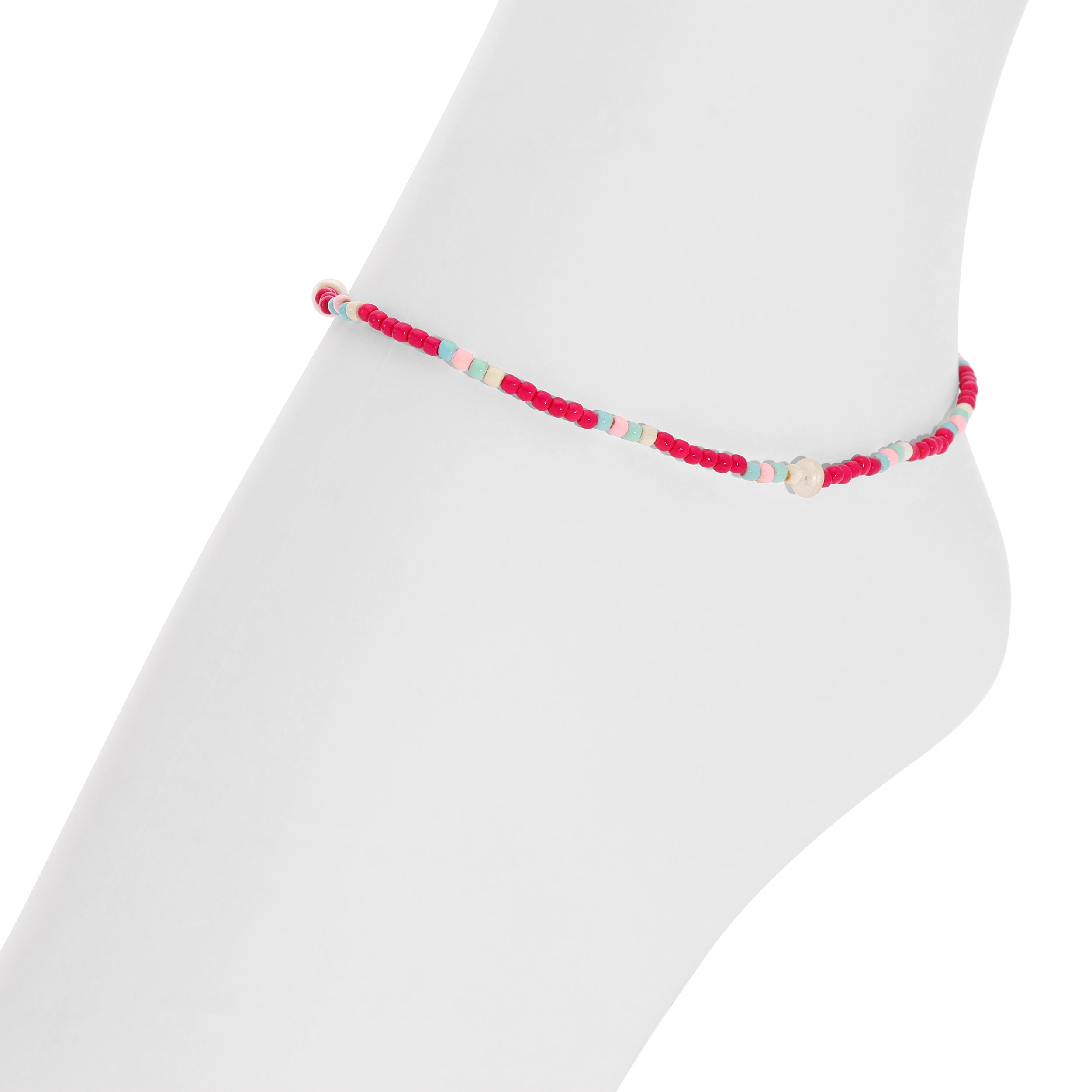 A delicate beaded anklet or bracelet in pink, red, and light blue, displayed on a white mannequin leg against a white background.