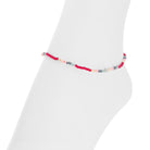 A delicate beaded anklet with alternating red, light pink, and gray beads, displayed on a white mannequin foot against a white background.